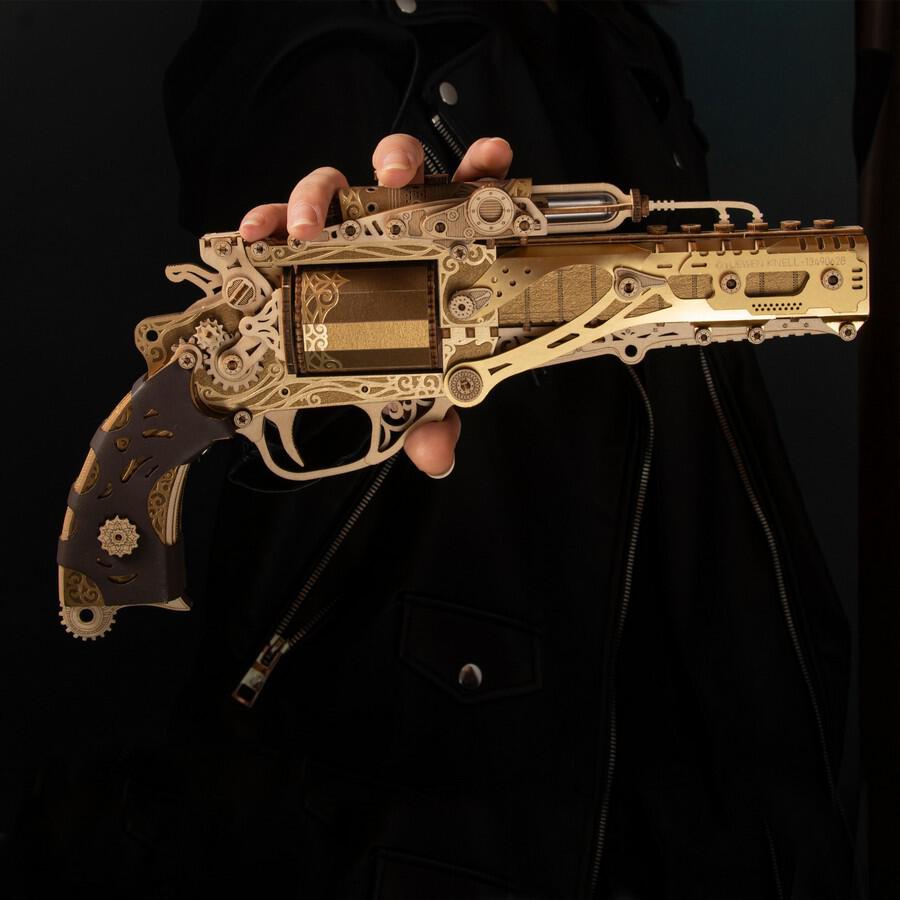 HowCat Steampunk Revolver Gold DIY 3D Wooden & Paper Puzzle held in hand, showcasing intricate design and craftsmanship.