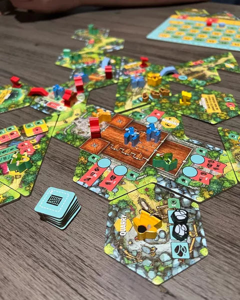 Hamlet The Village Building Board Game showing tile placement and player pieces on a wooden table.
